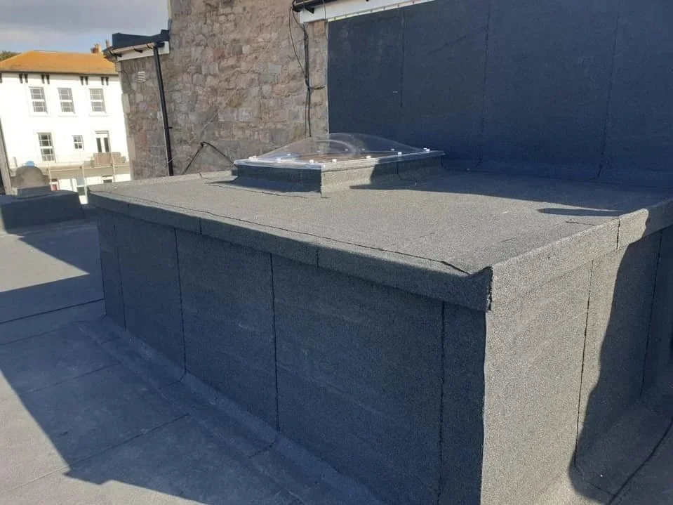 Completed flat roof detail beside a chimney
